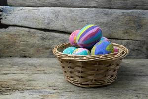 Easter eggs in the basket on wooden photo