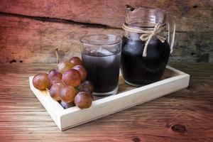 Fresh and juice grapes on wooden table photo