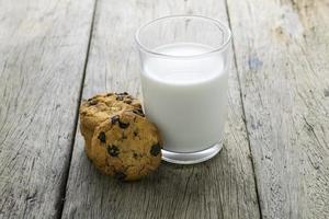 cookies and a glass with milk on wooden table photo