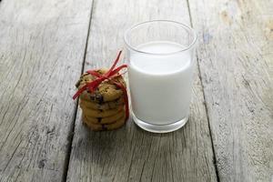 cookies and a glass with milk on wooden table photo