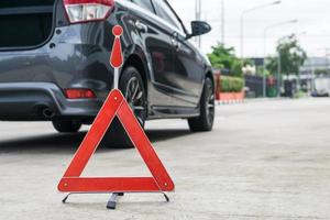 Broken car sign on a road with a broken down car photo