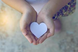 Children hands holding small model of heart and family , concept family photo