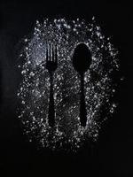 Fork and Spoon IMAGE ABOVE FLOUR, BLACK BACKGROUND. 12 FEBRUARY 2022 INDONESIA photo