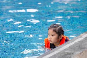 little kid girl swimming in outdoor pool, kids swimming in pool photo