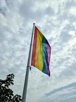 bandera del orgullo del arco iris en un asta de bandera. símbolo de la comunidad lgbt en colores del arco iris. foto