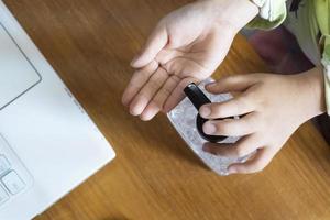 niña lavándose las manos con gel de alcohol o desinfectante de jabón antibacteriano cerca del escritorio de la computadora.concepto de higiene. prevenir la propagación de gérmenes y bacterias evitar infecciones corona virus o covid19 virus foto