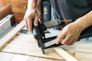 carpenter load nails into a nail gun ,furniture restoration woodworking concept. selective focus photo