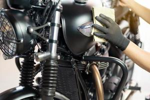 Biker man cleaning motorcycle , Polished and coating wax on fuel tank. repair and maintenance motorcycle concept. photo