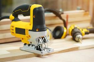 Power tool .Electric jig saw machine on Walnut Plywood in workshop, woodworking Handicraft and diy concept .selective focus photo