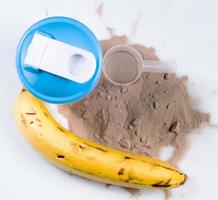 Shaker, protein powder and banana photo