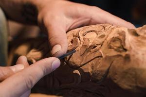 close up picture of woodcarver at work, handcrafting with wood photo