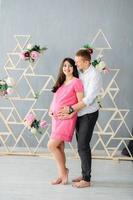 Couple With Pregnant Woman Relaxing On Sofa Together photo