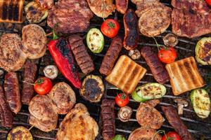 A large variety of grilled meat on the fire outside photo