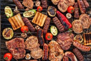 A large variety of grilled meat on the fire outside photo