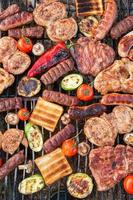 A large variety of grilled meat on the fire outside photo