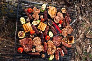 A large variety of grilled meat on the fire outside photo
