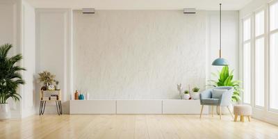 Cabinet for TV on the white plaster wall in living room with armchair,minimal design. photo