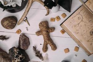 A voodoo doll made of rope lies with old book grimoire photo