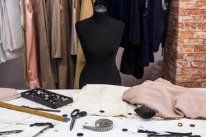 Design studio concept. Mannequin dummy, clothes hangers, dressmaking workplace photo