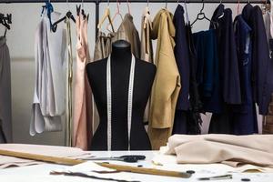 Design studio concept. Mannequin dummy, clothes hangers, dressmaking workplace photo