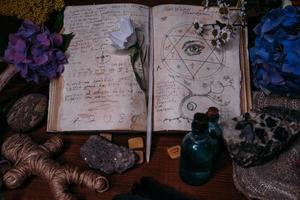 Open old book with magic spells, runes, black candle photo