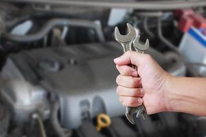 Car service. Hand holding wrench. photo