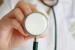 female doctor in white uniform holding stethoscope photo