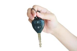 Hand holding car key isolated on white background photo