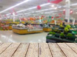 exhibición de productos de mostrador de madera con estantes de frutas en el fondo borroso del supermercado foto