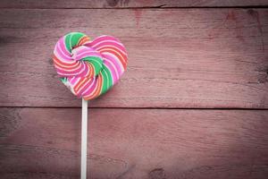 colorful heart lollipop on wood background