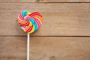 colorful heart lollipop on wood background photo