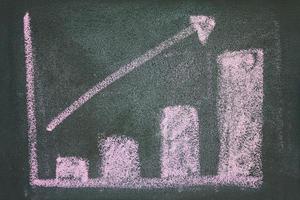 close up of chalkboard with growth business graph chart photo