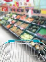 comprar algunas frutas y verduras en el supermercado con carrito de compras foto