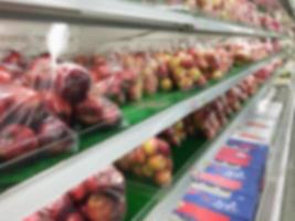 Shelf with fruits in supermarket blurred background photo