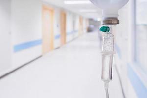 Medical drip with hospital blurred background photo