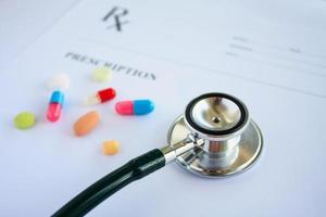 Pills and stethoscope on a prescription photo