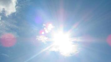 sun on the background of a blue sky with white clouds photo