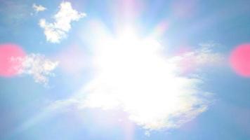 sol en el fondo de un cielo azul con nubes blancas foto