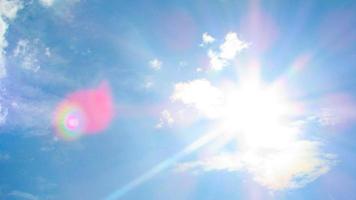 sun on the background of a blue sky with white clouds photo