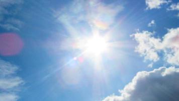 sun on the background of a blue sky with white clouds photo