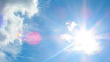 sol en el fondo de un cielo azul con nubes blancas foto