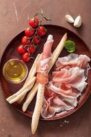 italian prosciutto ham grissini breadsticks tomato olive oil