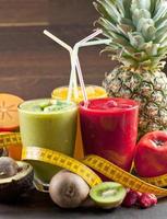 healthy fresh fruit and veg smoothie with assorted ingredients served in glass bottles with straws isolated on white background in panoramic banner photo