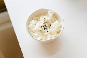 Plain rice with black sesame in a white plastic cup photo