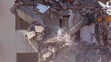 martillo hidráulico y máquina trasera de la excavadora cortadora de columnas trabajando en la demolición de antiguas casas de apartamentos video