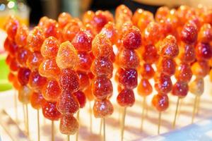The sugar coated strawberry skewers are embroidered on the foam board. Tanghulu crispy fruit