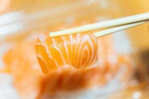 Salmon that has been pinched with chopsticks on a blurred background photo