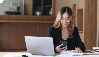 Asian businesswoman relax and enjoy playing mobile phone at office. photo