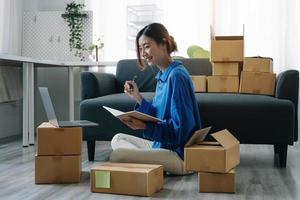Starting Small business entrepreneur freelance,Portrait young woman working at home office, BOX,smartphone,laptop, online, marketing, packaging, delivery, SME, e-commerce concept photo