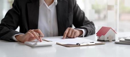 Businesswoman doing finances and calculate about cost to real estate investment. photo